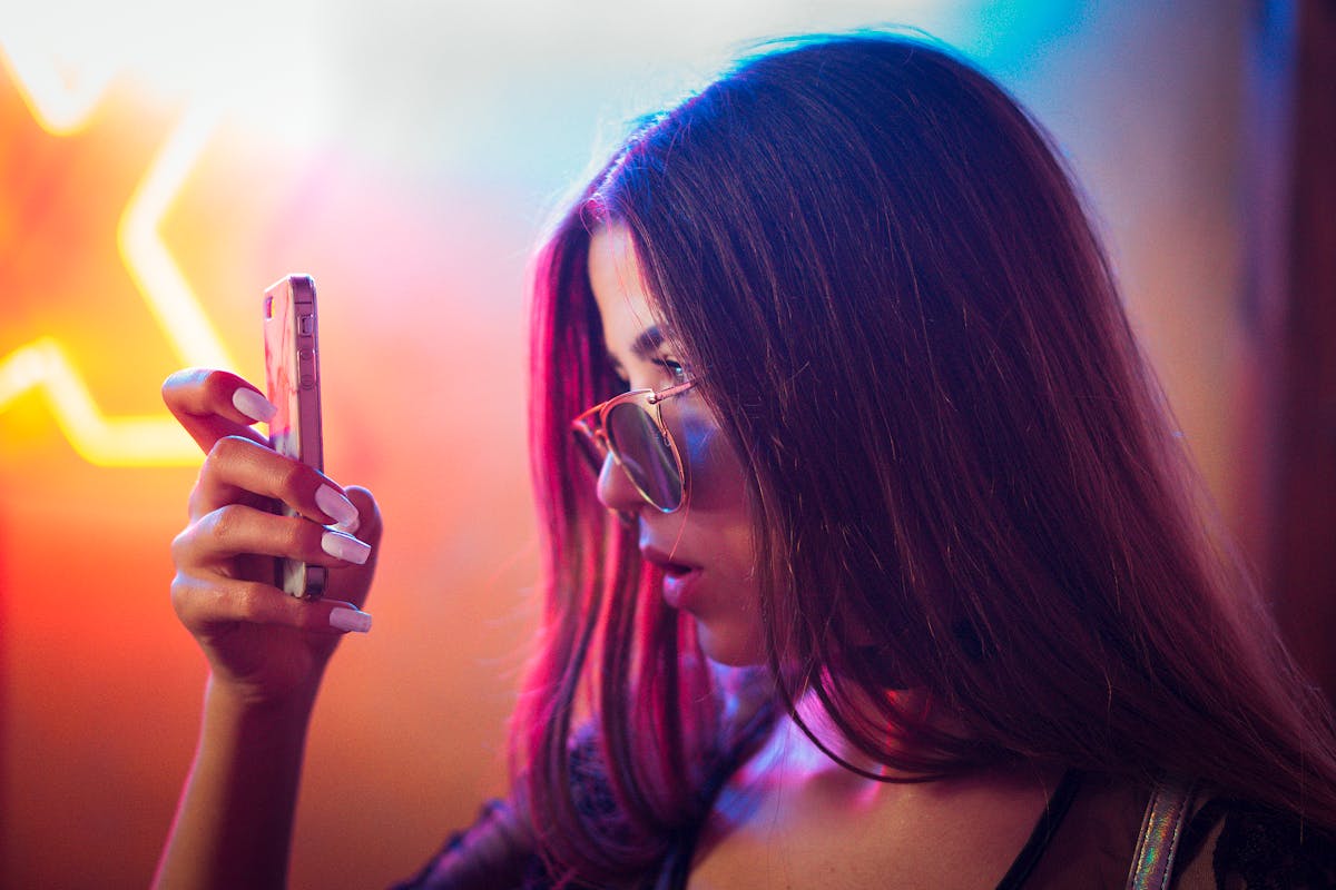 A creator filming a Reel on a phone in a bright, colorful room